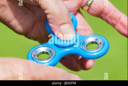 Fidget spinner. Hands spinning a fidget spinner. Stock Photo