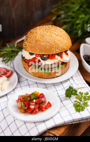 Delicious cheeseburger served on a crusty bread roll Stock Photo