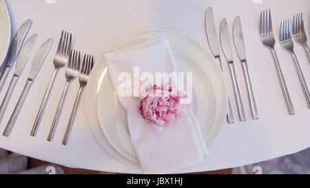 Spring table settings with fresh flower, napkin and silverware. Holidays background. Selective Focus Stock Photo