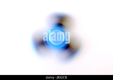 Top view of blue fidget spinner spinning on white background Stock Photo