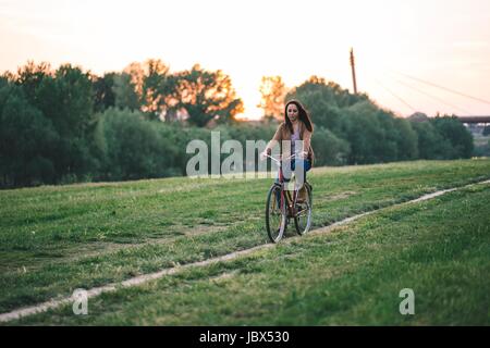 Woman riding bicycle on grass Stock Photo