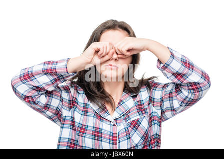 sleeping woman in pajamas rubbing his eyes with his hands on a white background Stock Photo
