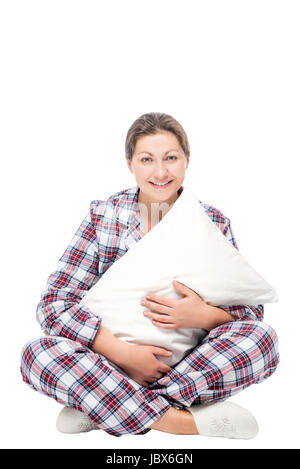Woman sitting on the floor hugging soft pillow against white background Stock Photo