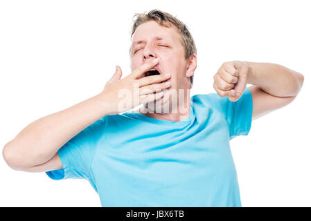 Sleepy man yawning and stretching before bed on white background Stock Photo