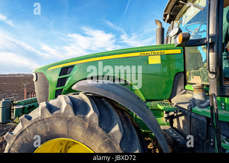 Varna, Bulgaria - March 5, 2017 Ploughing a field with John Deere tractor. John Deere was manufactured in 1995-1999 and it has JD 7.6L or 8.1L 6-cyl d Stock Photo