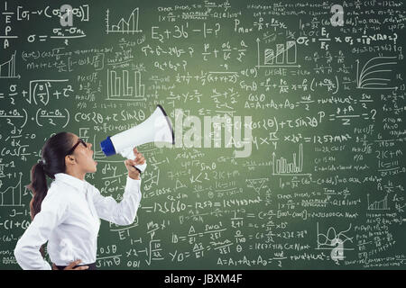 Businesswoman shouting through megaphone against green chalkboard with mathematical formula Stock Photo