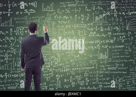Portrait of young man writing on blackboard with mathematical formula Stock Photo
