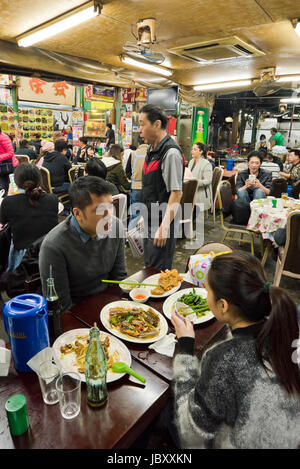 Vertical view inside a bustling streetfood restaurant in Hong Kong, China. Stock Photo