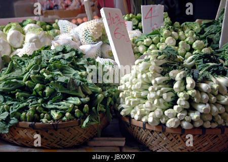 Horizontal close up of piles of fresh Chinese vegetables, Pak Choi, Choy Sum and chinese leaves for sale at an open air market in Hong Kong. Stock Photo