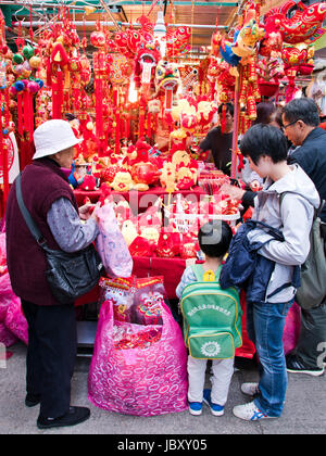 Vertical view of a family choosing Chinese New Year decorations at a market stall in Hong Kong, China. Stock Photo