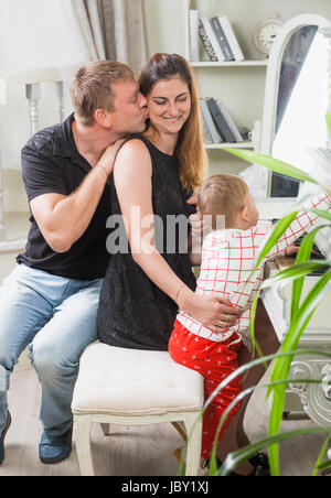 Portrait of happy young family sitting at the old piano Stock Photo