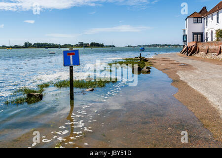 Rising tide flooding the seafront access road, Bosham, a south coast coastal village in Chichester Harbour, West Sussex, southern England, UK Stock Photo