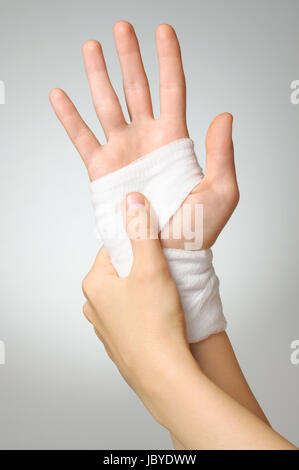 Injured painful hand with white bandage Stock Photo