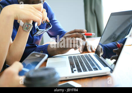 Teamwork,brainstorming concept.Young creative managers team working with new startup project in modern office. Contemporary notebook on wood table.Horizontal, film effect Stock Photo