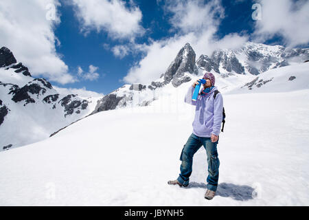 Climber breathing with mini portable oxygen cylinder to avoid and treat High Altitude Sickness symptom Stock Photo