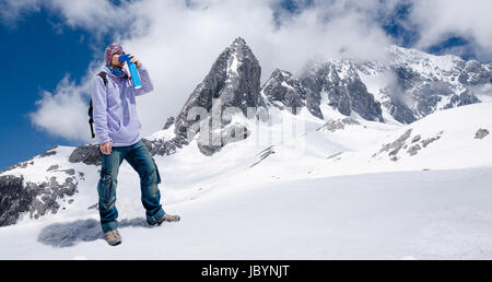 Climber breathing with mini portable oxygen cylinder to avoid and treat High Altitude Sickness symptom Stock Photo
