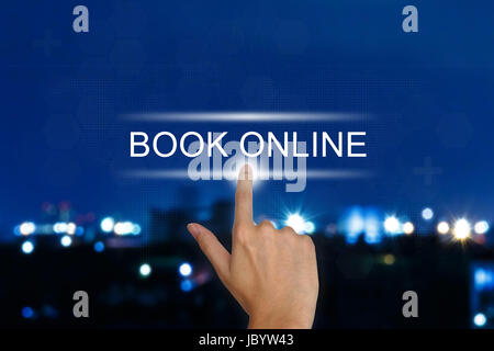 hand clicking book online button on a touch screen interface Stock Photo