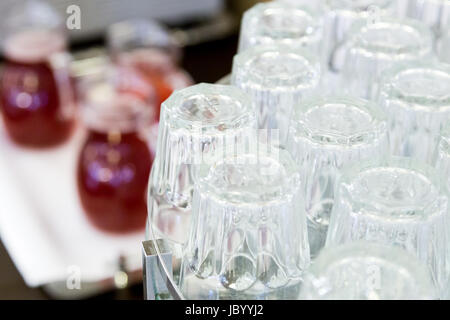 upside-down glasses on counter with gugs of red drink Stock Photo