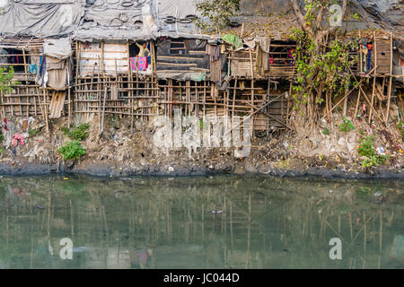 The dwellings and huts in Topsia slum are located at a dirty river Stock Photo