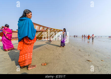 Women are drying her saris on the beach of Ganga Sagar, celebrating Maghi Purnima festival Stock Photo