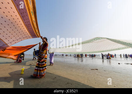 Women are drying her saris on the beach of Ganga Sagar, celebrating Maghi Purnima festival Stock Photo