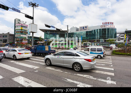 SEOUL, SOUTH KOREA - MAY 15: Cars drive on the road in front of Seoul train station and Lotte shopping mall in the downtonw district of the South Kore Stock Photo