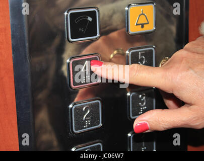 Female person pushing elevator button. Stock Photo