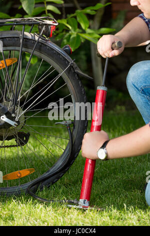 Closeup photo of young man pumping bicycle tyre Stock Photo