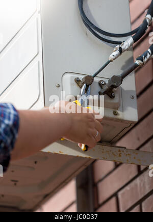Closeup photo of worker connecting pipes to air conditioning system Stock Photo