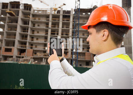 Portrait of young construction engineer using digital tablet on building site Stock Photo