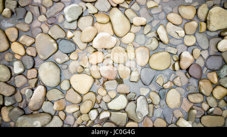 Top view on colorful pebbles covered by river water Stock Photo