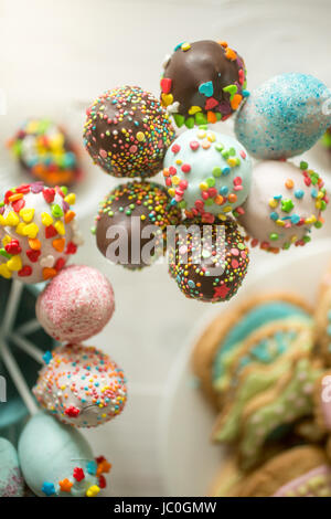 Beautiful decorated cake pops in cups on wooden table Stock Photo