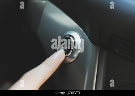 Closeup photo of woman pressing start engine button Stock Photo