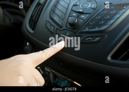 Closeup of woman pressing car emergency button Stock Photo