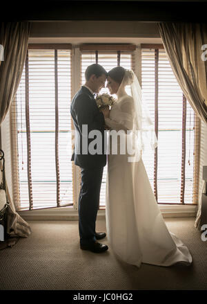 Toned photo of happy bride and groom sitting in plastic swing chair at ...