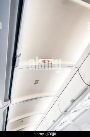 Photo of exit sign on ceiling on aircraft with lights Stock Photo