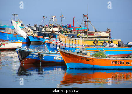 Colorful fishing boats anchored in Paracas Bay, Peru. Paracas is a small port town catering to tourists visiting Paracas Reserve and Ballestas islands Stock Photo