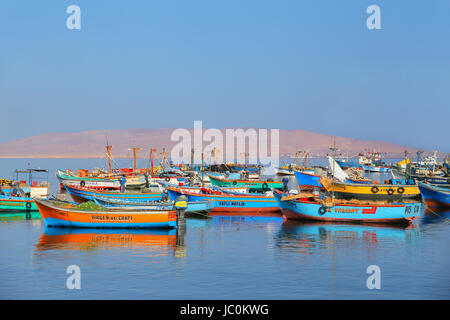 Colorful fishing boats anchored in Paracas Bay, Peru. Paracas is a small port town catering to tourists visiting Paracas Reserve and Ballestas islands Stock Photo