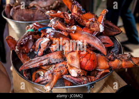 Photo of frozen lobster claws in metal bucket at restaurant Stock Photo