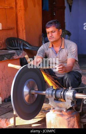 Local man sharpening tool at Johari Bazaar street in Jaipur, Rajasthan, India. Jaipur is the capital and the largest city of Rajasthan. Stock Photo