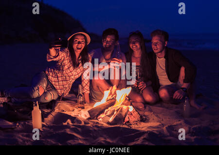 riends sitting on beach and take selfie Stock Photo