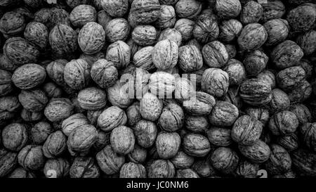 Closeup black and white texture of raw walnuts in shells Stock Photo