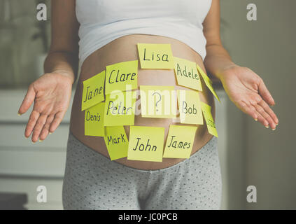Toned photo of pregnant woman with child names on belly Stock Photo