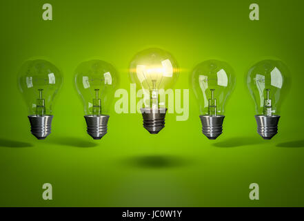 One glowing bulb in row of light bulb on green background Stock Photo