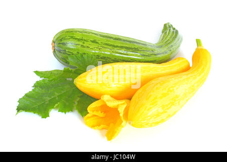 gelbe und grüne Zucchini mit einem Blatt und einer Blüte frreigestellt vor weißem Hintergrund Stock Photo