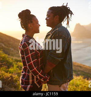 Mixed race couple holding hands outdoors in a beautiful landscape Stock Photo