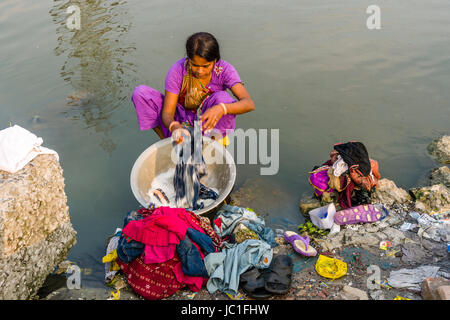 A woman, dhobi, is doing laundry at a lake in the suburb Topsia Stock Photo