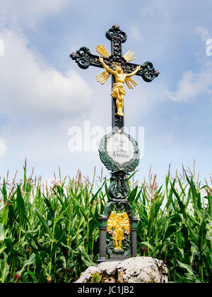 Wrought iron wayside cross with lettering 'Praised be Jesus Christ' in German language. Stock Photo