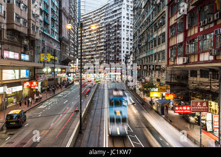 HONG KONG - APRIL 21, 2017: A tram car rushes through the working class district of North Point at night in Hong Kong island. The tramway is a traditi Stock Photo
