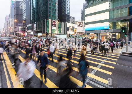 HONG KONG - APRIL 26, 2017: People, captured with blurred motion, cross Nathan road in the very crowded Mong Kok shopping district  in Kowloon. Stock Photo